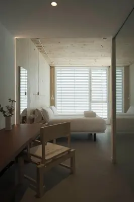 a room with a bed and a table and a bench at Hotel Amiuka in O Pedrouzo