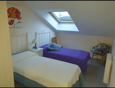 a attic bedroom with two beds and a skylight at CANTABRICO in Barreiros