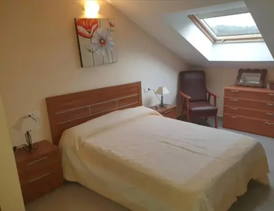 a bedroom with a bed and a chair and a window at CANTABRICO in Barreiros