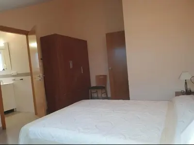 a bedroom with a white bed and a wooden cabinet at CANTABRICO in Barreiros