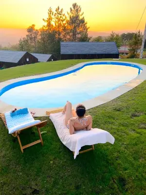 a woman in a bikini laying on a towel next to a pool at O rincón dos Sentidos in Cenlle