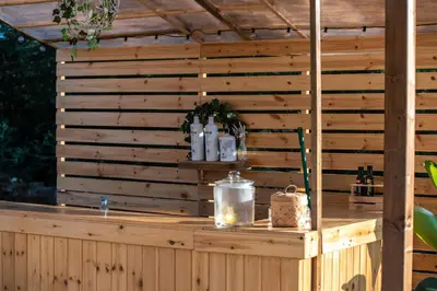 a wooden bar with bottles of wine and candles at O rincón dos Sentidos in Cenlle