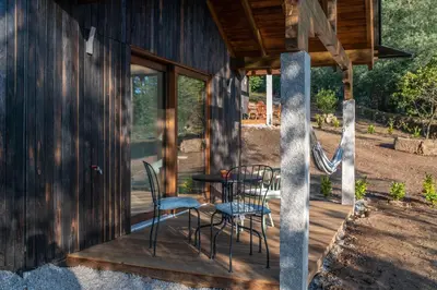 a porch with chairs and a table and a slide at O rincón dos Sentidos in Cenlle