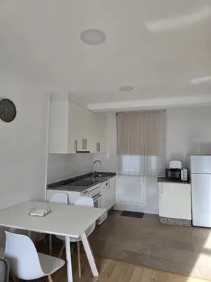 a kitchen with a white table and white appliances at Pote in Lugo