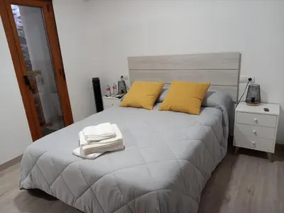 a bedroom with a bed with two yellow pillows at Hotel Rural Virgen del Carmen in Molinaseca