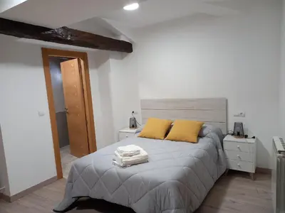a bedroom with a bed with two yellow pillows at Hotel Rural Virgen del Carmen in Molinaseca