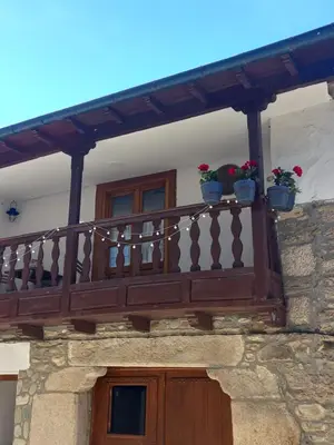 a wooden balcony with two potted plants on it at Hotel Rural Virgen del Carmen in Molinaseca