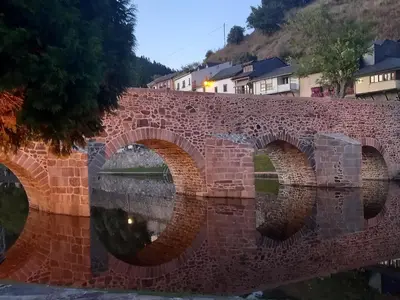a brick bridge over a body of water at Hotel Rural Virgen del Carmen in Molinaseca