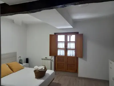 a bedroom with a bed and a wooden door at Hotel Rural Virgen del Carmen in Molinaseca