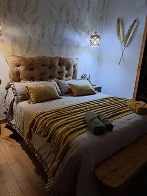 a bedroom with a large bed with a wooden headboard at El Rincón del Val in Priaranza del Bierzo