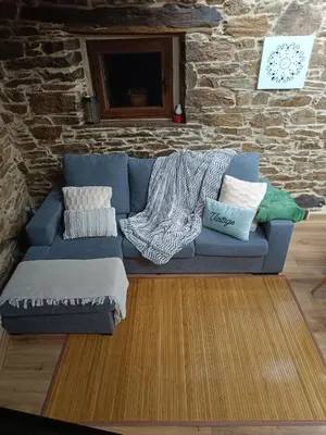 a blue couch sitting in a living room with pillows at El Rincón del Val in Priaranza del Bierzo