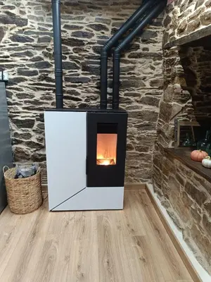 a fireplace in a living room with a stone wall at El Rincón del Val in Priaranza del Bierzo