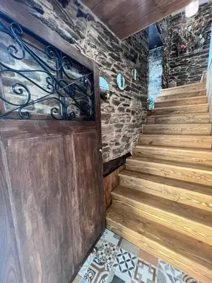 a staircase in a house with a wooden door at El Rincón del Val in Priaranza del Bierzo