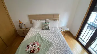 a bedroom with a white bed with flowers on it at Casa Sanjurjo in Monforte de Lemos