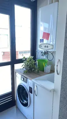 a washer and dryer in a kitchen next to two windows at Casa Sanjurjo in Monforte de Lemos