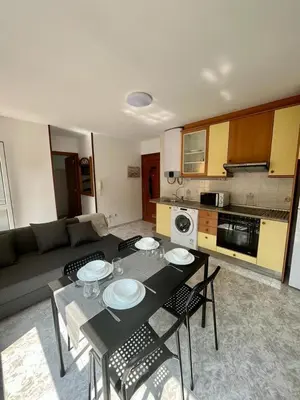 a kitchen and living room with a table and chairs at RAXEL - MIÑO in Miño