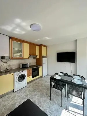 a kitchen with a table and a dining room at RAXEL - MIÑO in Miño