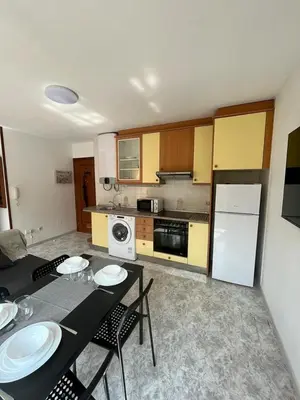 a kitchen with a table and chairs and a refrigerator at RAXEL - MIÑO in Miño