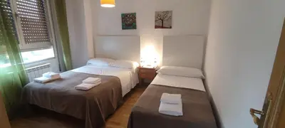 a small room with two beds and a window at El Cruce 1 y 2 in Villafranca del Bierzo