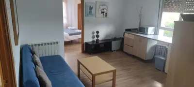 a living room with a blue couch and a table at El Cruce 1 y 2 in Villafranca del Bierzo