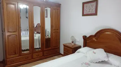 a bedroom with a large wooden cabinet and a bed at PISO MANCE in Allariz