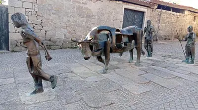 a statue of a boy and a statue of a cow at PISO MANCE in Allariz