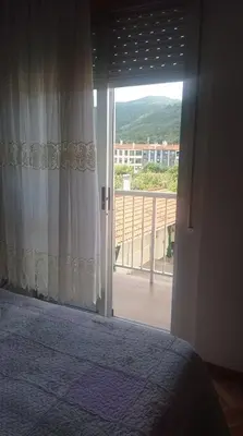 a bedroom with a bed and a door to a balcony at PISO MANCE in Allariz