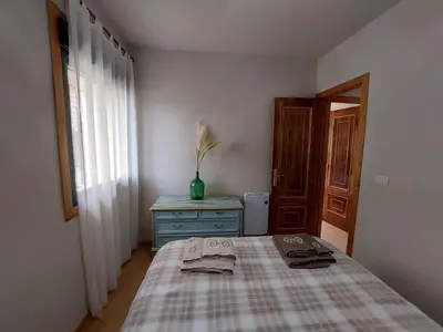 a bedroom with a bed and a dresser and a window at FOGAR CAÑÓN DO SIL - En la Ribeira Sacra in Nogueira de Ramuin
