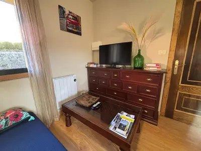 a living room with a dresser with a television on it at FOGAR CAÑÓN DO SIL - En la Ribeira Sacra in Nogueira de Ramuin