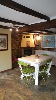 a white table and two green chairs in a room at Pensión Albergue A Pedra in Sarria