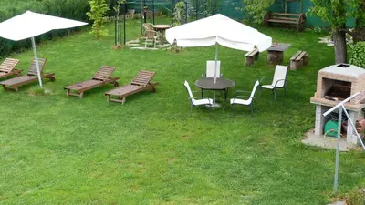 an outdoor grill with chairs and tables and umbrellas at Pensión Albergue A Pedra in Sarria