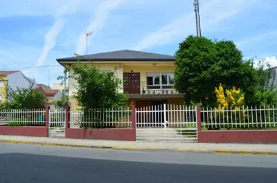 a yellow house with a white picket fence at Casa Matilde de Melide in Melide
