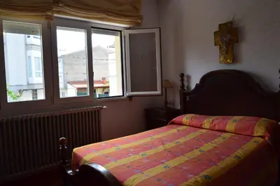 a bedroom with a bed and a window at Casa Matilde de Melide in Melide