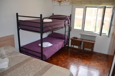 a bedroom with two bunk beds with purple sheets at Casa Matilde de Melide in Melide