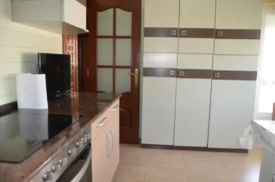 a kitchen with white cabinets and a stove top oven at Casa Matilde de Melide in Melide