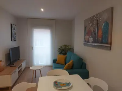 a living room with a blue couch and a table at Apartamento Silleda Confort in Silleda