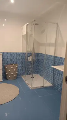 a bathroom with a shower in a blue tiled room at Apartamento Silleda Confort in Silleda