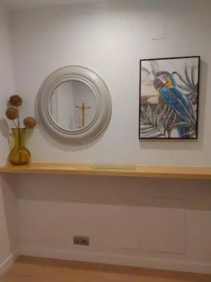 a shelf with a mirror and a cross on a wall at Apartamento Silleda Confort in Silleda