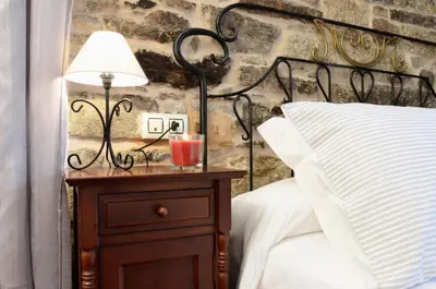 a lamp on a night stand next to a bed at Sete Artes by Como en Casa in Santiago de Compostela