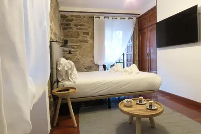 a hotel room with a bed and a tv at Sete Artes by Como en Casa in Santiago de Compostela