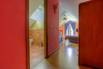 a room with a red door leading to a bedroom at Hostal Rural La Tintoreria in Villablino