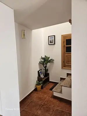 a hallway with white walls and a staircase with a door at Casa Lina VUT OR 000784 in Allariz