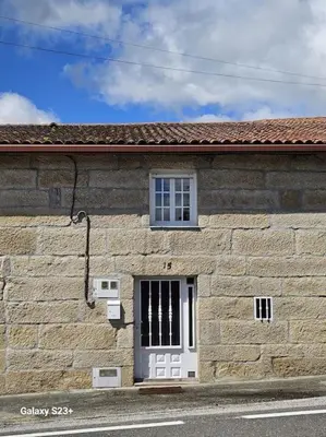 a stone building with a white door and a window at Casa Lina VUT OR 000784 in Allariz