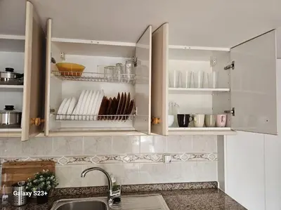 a kitchen with white cabinets with plates and utensils at Casa Lina VUT OR 000784 in Allariz