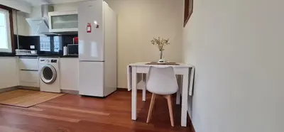 a small table with a vase on it in a kitchen at Estudio céntrico con terraza in Xinzo de Limia