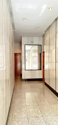 a hallway of a building with white tile walls at Estudio céntrico con terraza in Xinzo de Limia
