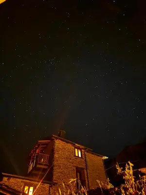 a night view of a building with lights on at Lar da cima in Folgoso
