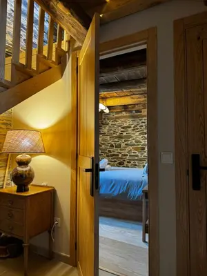 a door leading to a bedroom with a bed at Lar da cima in Folgoso