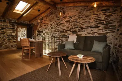 a living room with a couch and two tables at A Barreira -Lar da cima- in Folgoso
