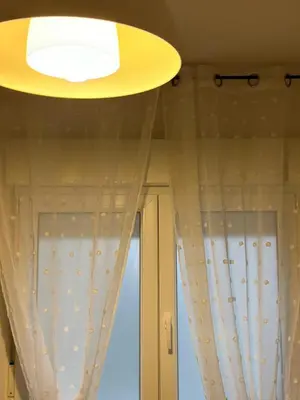 a ceiling light and a window with curtains at Piso da Ulla in A Estrada